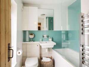 a bathroom with a toilet and a sink and a tub at Beckside Cottage in Welton +12 photos