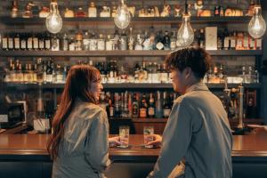 two women standing at a bar talking at Anchor Hotel Fukuyama in Fukuyama