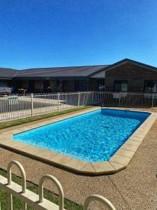 een groot blauw zwembad voor een gebouw bij Allara Motor Lodge in Bendigo