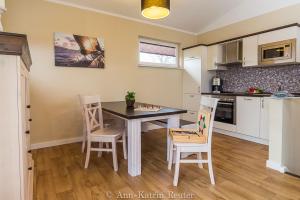 cocina con mesa de comedor y sillas en Lietzow Appartementhaus Möwe Haus Möwe - Ferienwohnung 3 "Lachmöwe", en Lietzow