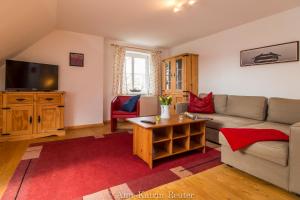 Una sala de estar con un sofá y un televisor. en Gutshof Dubnitz -Ferienwohnung 9 " Elsa ", en Dubnitz