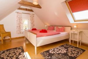 Un dormitorio con una cama con almohadas rojas y una ventana. en Gutshof Dubnitz -Ferienwohnung 9 " Elsa ", en Dubnitz