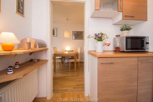 eine Küche mit Mikrowelle und ein Esszimmer in der Unterkunft Ferienhaus Am Ufer - Ferienwohnung Strandluft in Sassnitz