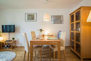 ein Esszimmer mit einem Holztisch und Stühlen in der Unterkunft Ferienhaus Am Ufer - Ferienwohnung Strandluft in Sassnitz