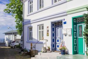 ein Haus mit einer blauen und grünen Tür auf einer Straße in der Unterkunft Ferienhaus Am Ufer - Ferienwohnung Strandluft in Sassnitz