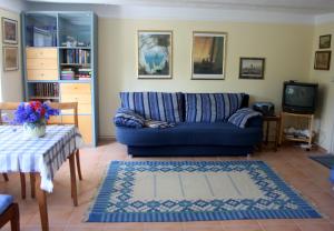 a living room with a blue couch and a table at Im Feriengarten - Ferienwohnung EG in Nardevitz