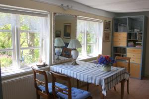 een eetkamer met een tafel en twee ramen bij Im Feriengarten - Ferienwohnung EG in Nardevitz