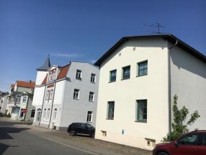 un bâtiment blanc sur le côté d'une rue dans l'établissement Haus "Georgina" - Ferienwohnung 2, à Sassnitz