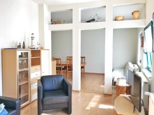 - un salon avec une chaise et une table dans l'établissement Haus "Georgina" - Ferienwohnung 2, à Sassnitz