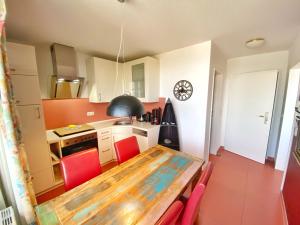 a kitchen with a wooden table and red chairs at Appartements am Rondell Neddesitz, Appartement 310 in Neddesitz