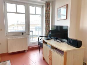 een kamer met een bureau, een televisie en een raam bij Appartements am Rondell Neddesitz, Appartement 310 in Neddesitz