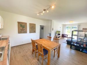 cocina y sala de estar con mesa de madera y sillas en Ferienhaus Polchow - Ferienwohnung EG "Heimathafen", en Polchow