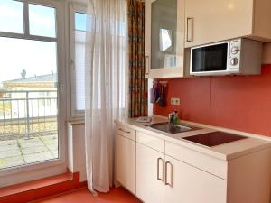 a kitchen with a sink and a microwave and a window at Appartements am Rondell Neddesitz, Appartement 306 in Neddesitz