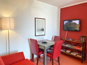 a dining room with a table and red chairs at Appartements am Rondell Neddesitz, Appartement 306 in Neddesitz