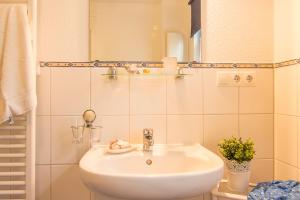 Baño blanco con lavabo y espejo en Ferienanlage Kap Arkona - App 7, en Putgarten