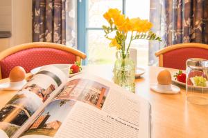 una mesa con un libro sobre una mesa con flores en Ferienanlage Kap Arkona - App 7, en Putgarten