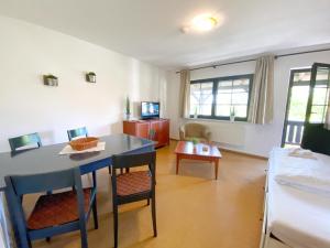 sala de estar con mesa, sillas y cama en Landpension Dubnitz Landpension Dubnitz - Ferienwohnung 4, 