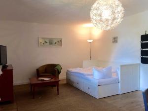 1 dormitorio con 1 cama, 1 silla y 1 lámpara de araña en Landpension Dubnitz Landpension Dubnitz - Ferienwohnung 7, 