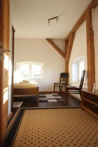 ein Schlafzimmer mit einem Bett und einem Stuhl in einem Zimmer in der Unterkunft Gutshof Dubnitz Gutshof Dubnitz -Ferienwohnung 4 " Anna " 