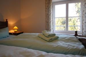 a bed with towels on it with a window at Gutshof Dubnitz Gutshof Dubnitz -Ferienwohnung 5 " Dörthe " in Dubnitz
