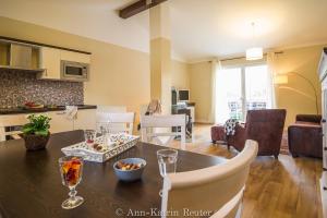 eine Küche und ein Wohnzimmer mit Tisch und Stühlen in der Unterkunft Lietzow Appartementhaus Möwe Haus Möwe - Ferienwohnung 2 "Fischmöwe" in Lietzow