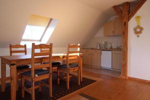 eine Küche mit einem Tisch und Stühlen im Zimmer in der Unterkunft Gutshof Dubnitz Gutshof Dubnitz -Ferienwohnung 8 " Sammy " 