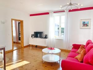 a living room with a red couch and a table at Sassnitz - Seaside Appartements Seaside Appartements, "Red" in Sassnitz