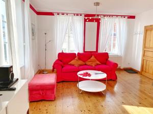 a living room with a red couch and a table at Sassnitz - Seaside Appartements Seaside Appartements, "Red" in Sassnitz