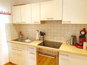 a kitchen with white cabinets and a sink at Sassnitz - Seaside Appartements Seaside Appartements, "Red" in Sassnitz
