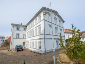 um carro estacionado em frente a um grande edifício branco em Sassnitz - Seaside Appartements Seaside Appartements, "Grey" em Sassnitz