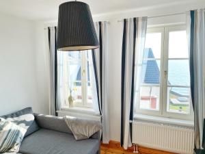 uma sala de estar com um sofá e duas janelas em Sassnitz - Seaside Appartements Seaside Appartements, "Grey" em Sassnitz