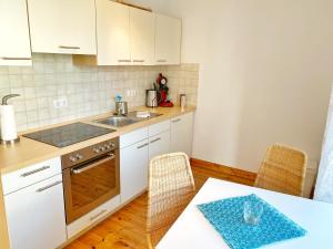 a kitchen with white cabinets and a table and a sink at Sassnitz - Seaside Appartements Seaside Appartements, "Grey" in Sassnitz