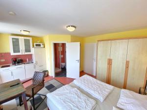 een slaapkamer met een bed en een tafel en een keuken bij Appartements am Rondell Neddesitz, Appartement 308 in Neddesitz