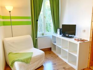 Zimmer mit einem TV und einem Stuhl in einem Zimmer in der Unterkunft Sassnitz - Seaside Appartements Seaside Appartements, "Green" in Sassnitz