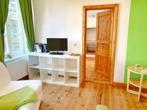 a room with a tv and a bed and a table at Sassnitz - Seaside Appartements Seaside Appartements, "Green" in Sassnitz +4 photos