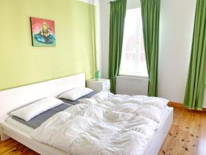 a white bed in a bedroom with green curtains at Sassnitz - Seaside Appartements Seaside Appartements, "Green" in Sassnitz