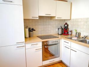 a kitchen with white cabinets and a stove top oven at Sassnitz - Seaside Appartements Seaside Appartements, "Green" in Sassnitz