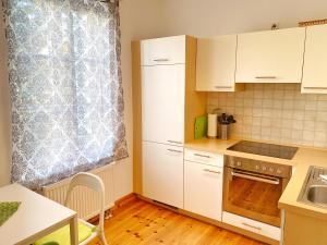eine kleine Küche mit weißen Schränken und einem Fenster in der Unterkunft Sassnitz - Seaside Appartements Seaside Appartements, "Green" in Sassnitz