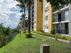 a park in front of a building with palm trees at Full furnished apartment in Pereira in Pereira