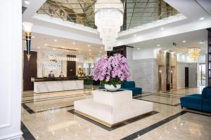 a lobby of a hotel with purple flowers in a vase at Thiên Ân Hotel Bắc Giang in Bắc Giang +34 photos