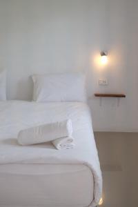 - un lit blanc avec des draps blancs et des serviettes dans l'établissement Jasmine Resort, à Buriram