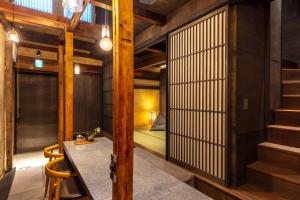 a room with wooden walls and stairs and a table and chairs at Kyo no oozora KIHANA in Kyoto