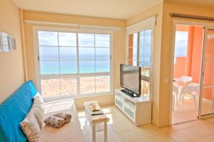uma sala de estar com um sofá e uma televisão em Playa Paraiso em Costa Calma