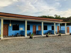 a blue building with picnic tables in front of it at D'pinggir Guest Room in Kuala Tahan