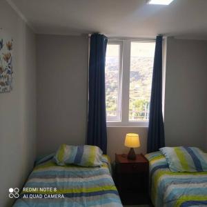 - une chambre avec 2 lits et une fenêtre dans l'établissement CONDOMINIO MONDRIAN, à Quilpué