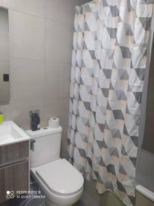 La salle de bains est pourvue de toilettes et d'un rideau de douche. dans l'établissement CONDOMINIO MONDRIAN, à Quilpué