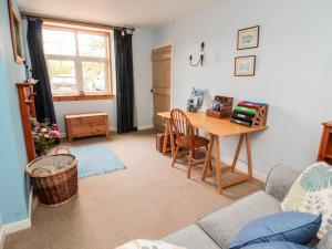 a living room with a table and a desk at 5 Swinton Mill Farm Cottage in Coldstream
