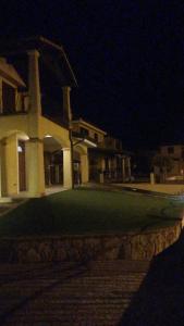 Casa la rosa dei venti في كارديدو: مبنى كبير في الليل مع ساحة خضراء