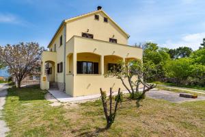 une maison jaune avec un arbre devant elle dans l'établissement Apartment Mari - with view, à Novigrad