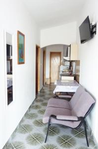 Apartments Bozica - 70m from the beach & parking في فير: غرفة معيشة مع كرسي وأريكة
